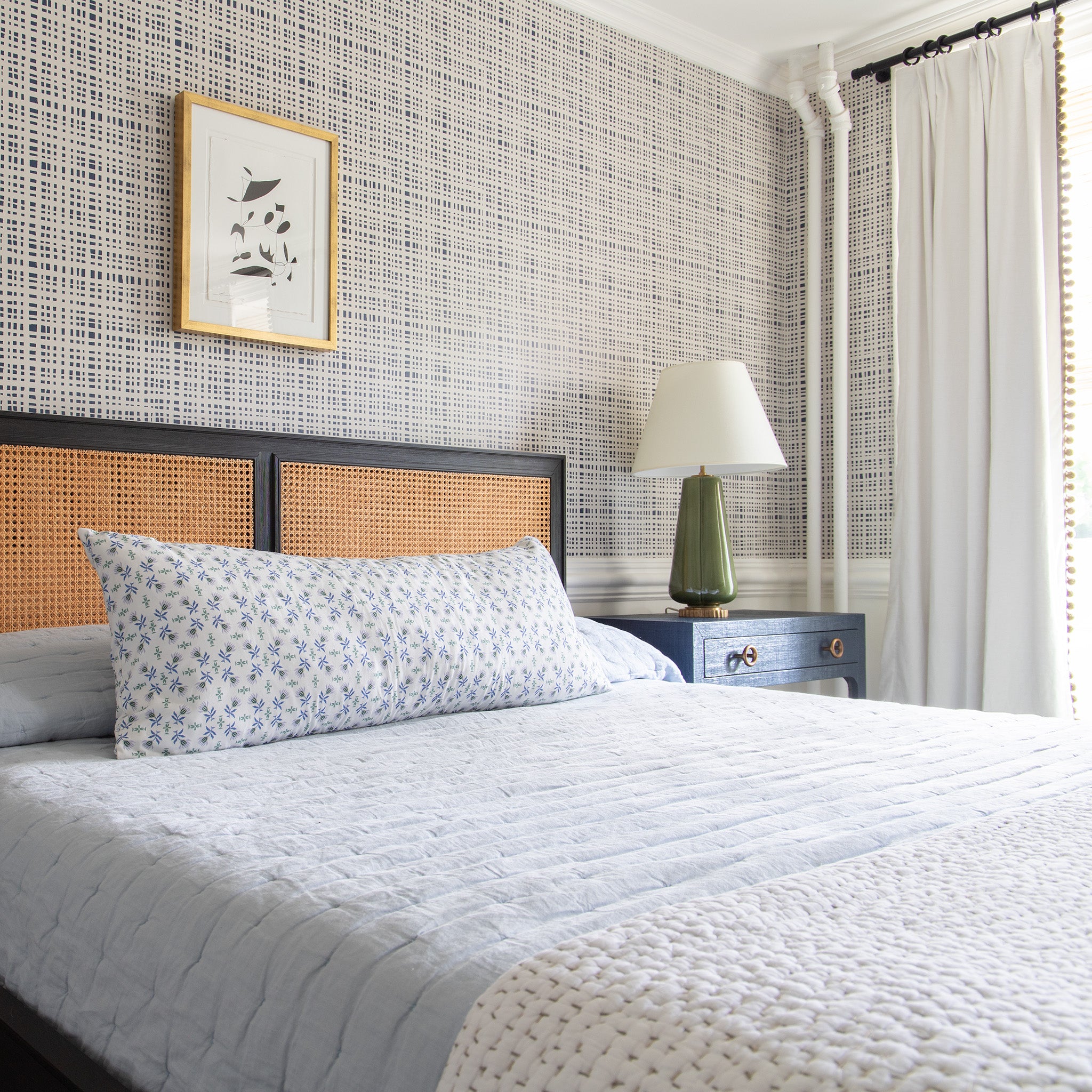 Bedroom styled with black gingham printed wallpaper over sky blue bed with a Blue & Green Floral Printed Lumbar on top next to blue wooden nightstand with white and moss green lamp on top