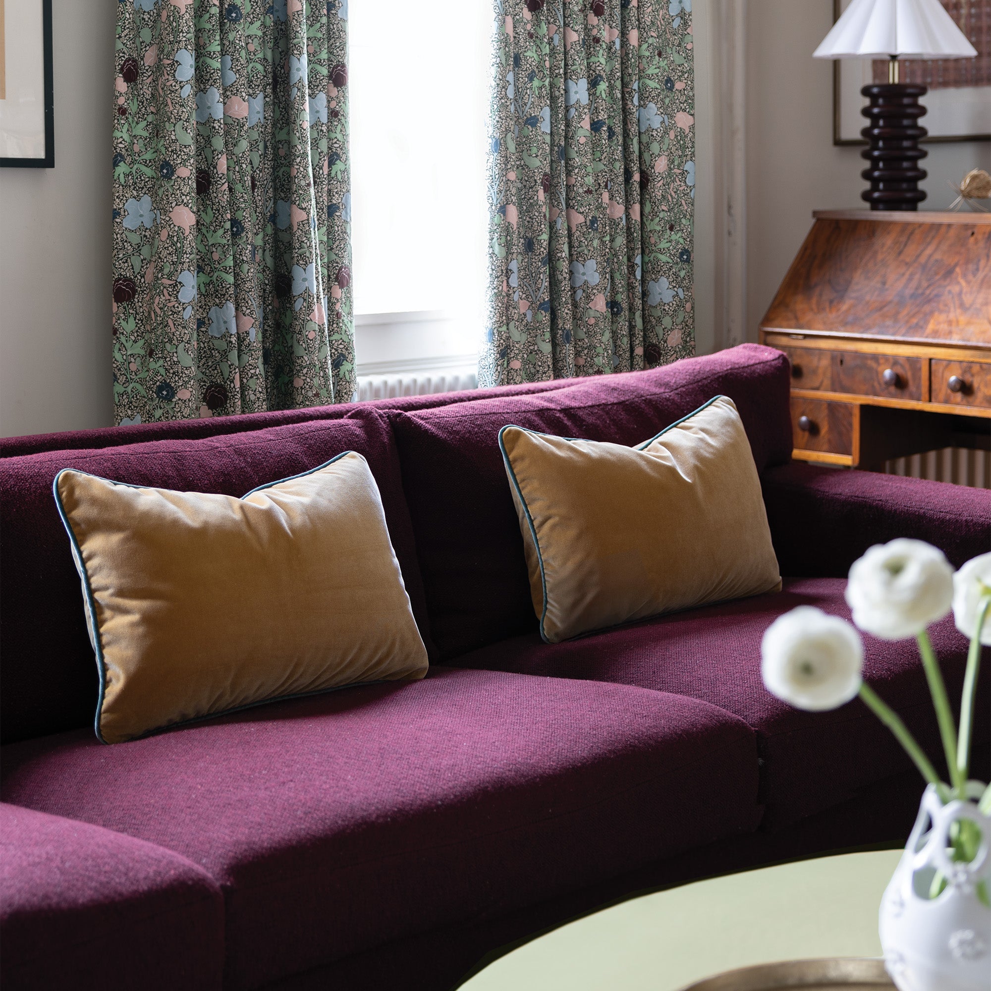 Camel Velvet cushions on a purple sofa add warmth and luxury to this elegant, cozy living space by Pepper Home.