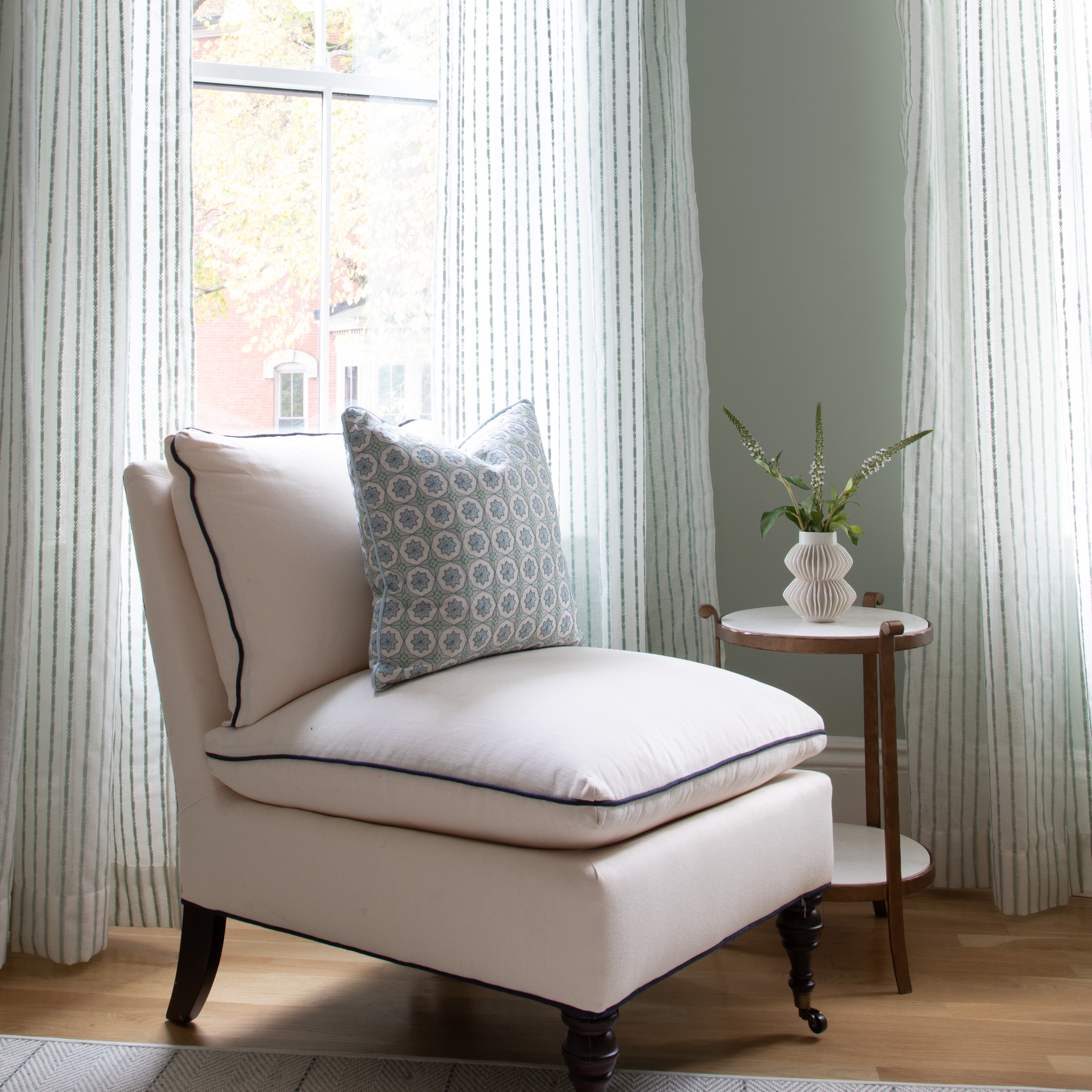 Madeline Mint sheer curtains with embroidered green stripes softly filter light, enhancing room with delicate custom style.
