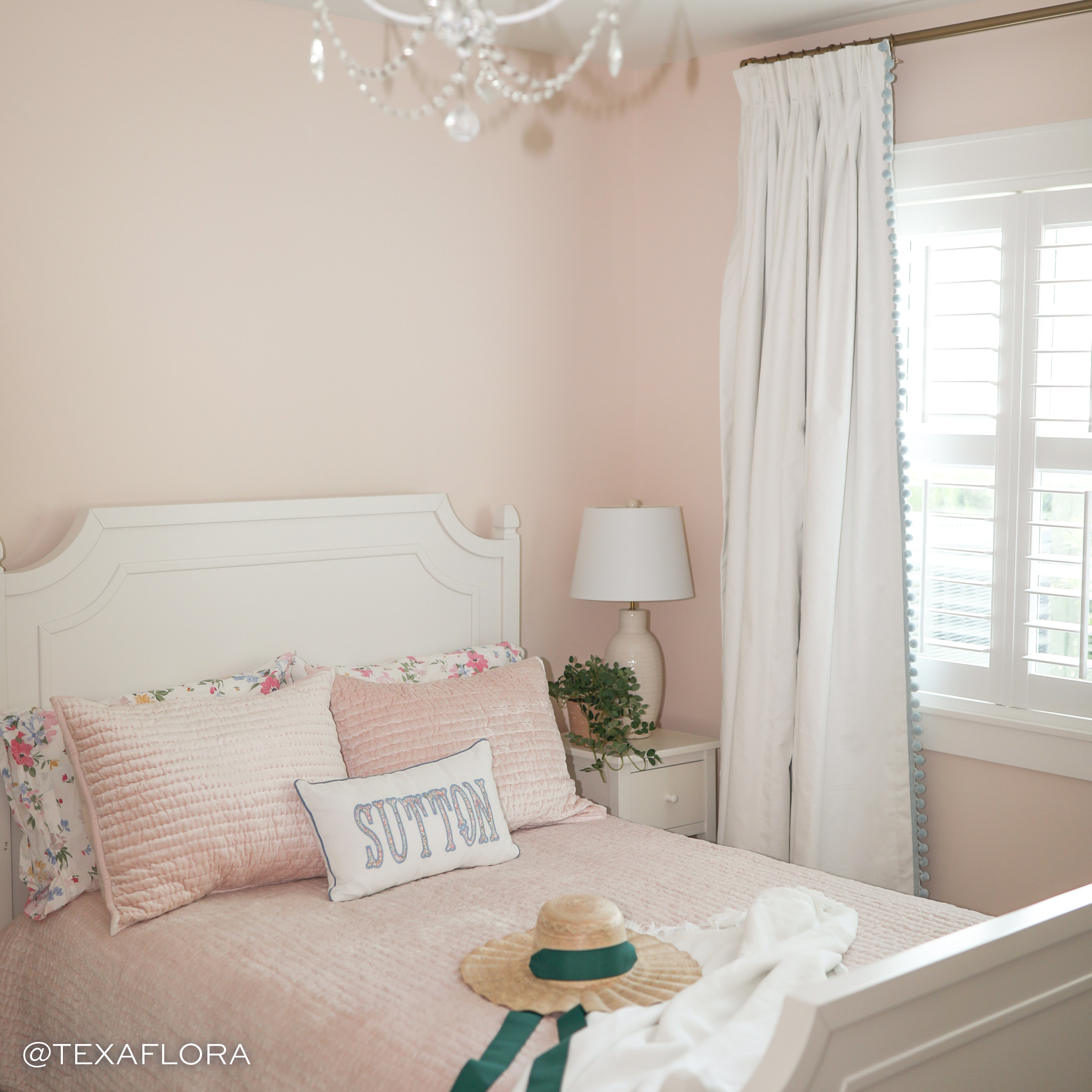 White Cotton Curtains in a pink room behind a bed with pink bedding and straw hat