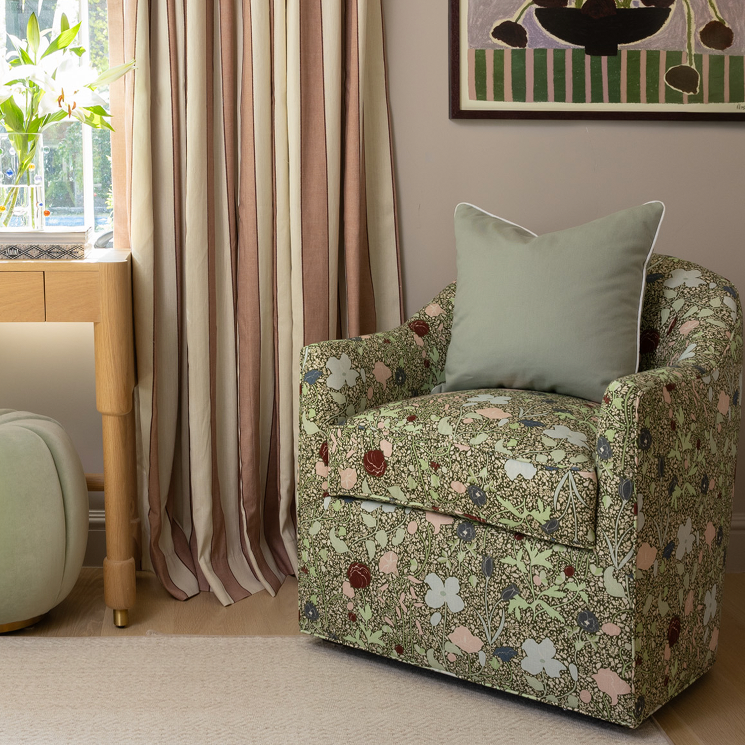 Sage floral patterned armchair with green pillow near custom striped curtains by Pepper Home.