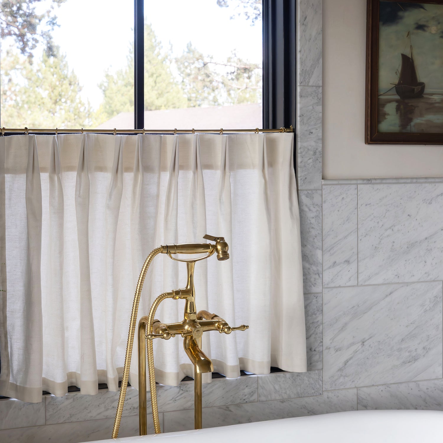 Soft ivory Flour custom linen-cotton blend cafe curtains hanging in bright bathroom window with gold faucet fixtures