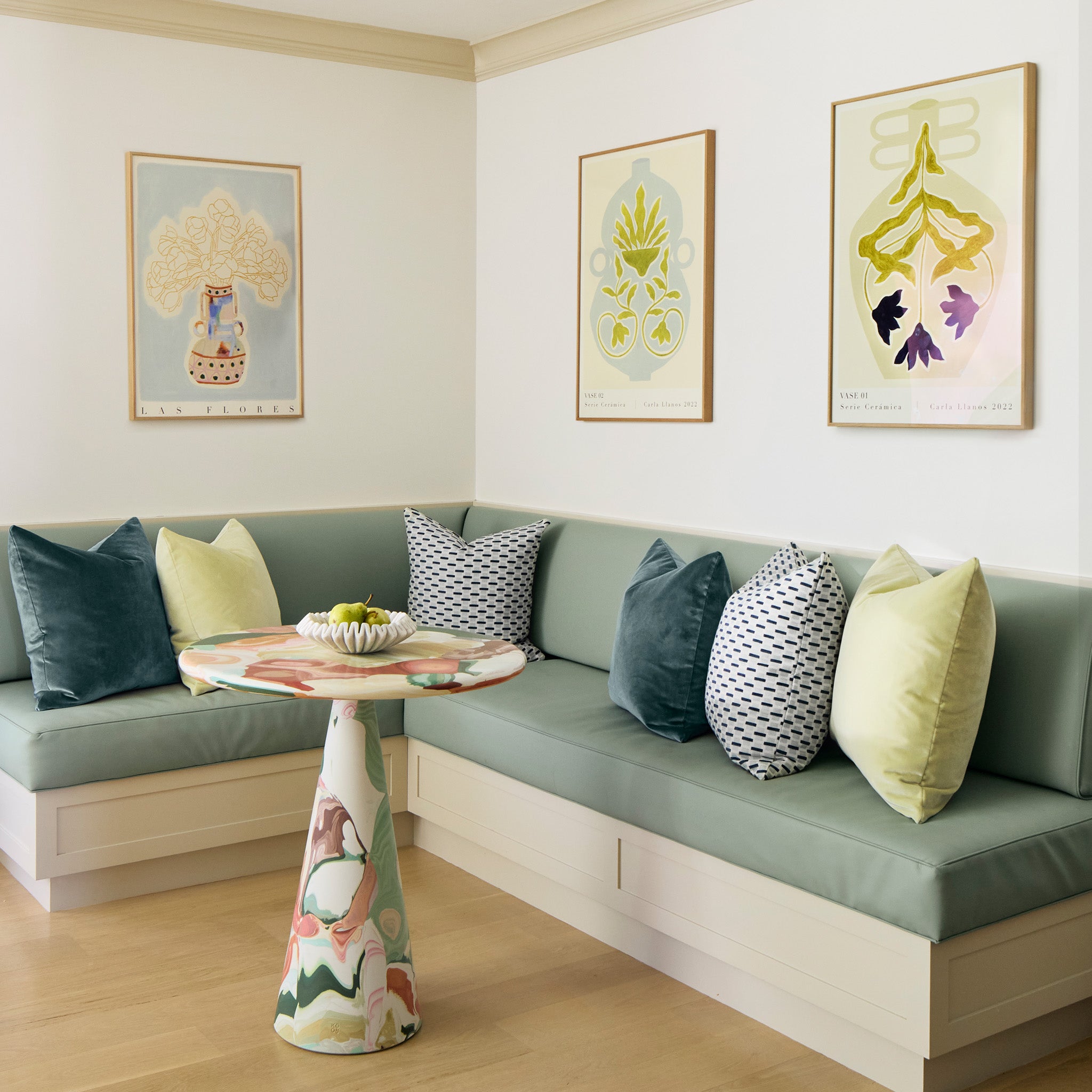 kitchen table nook with floral art and blue and green pillows