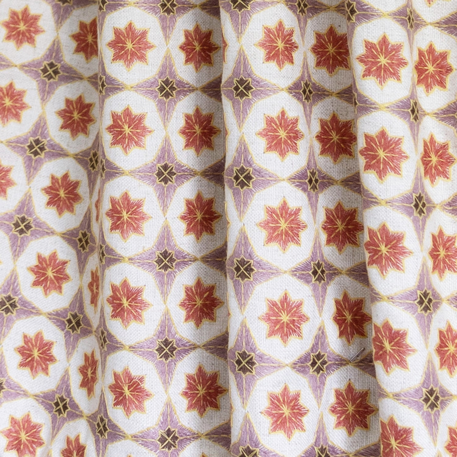 Close-up of Hayes Coral Unlined fabric showcasing intricate geometric embroidery and durable linen blend texture.