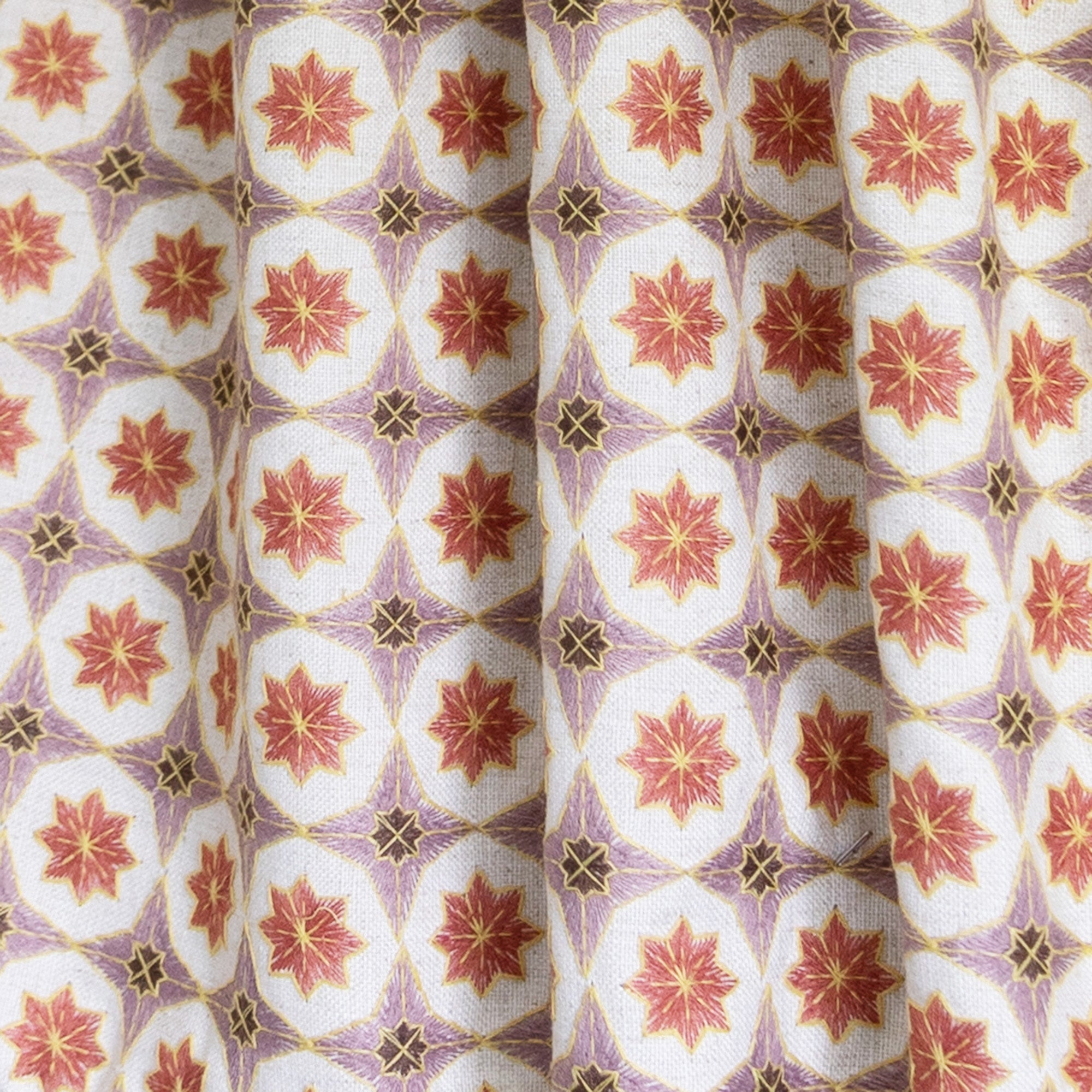 Close-up of Hayes Coral Unlined fabric showcasing intricate geometric embroidery and durable linen blend texture.