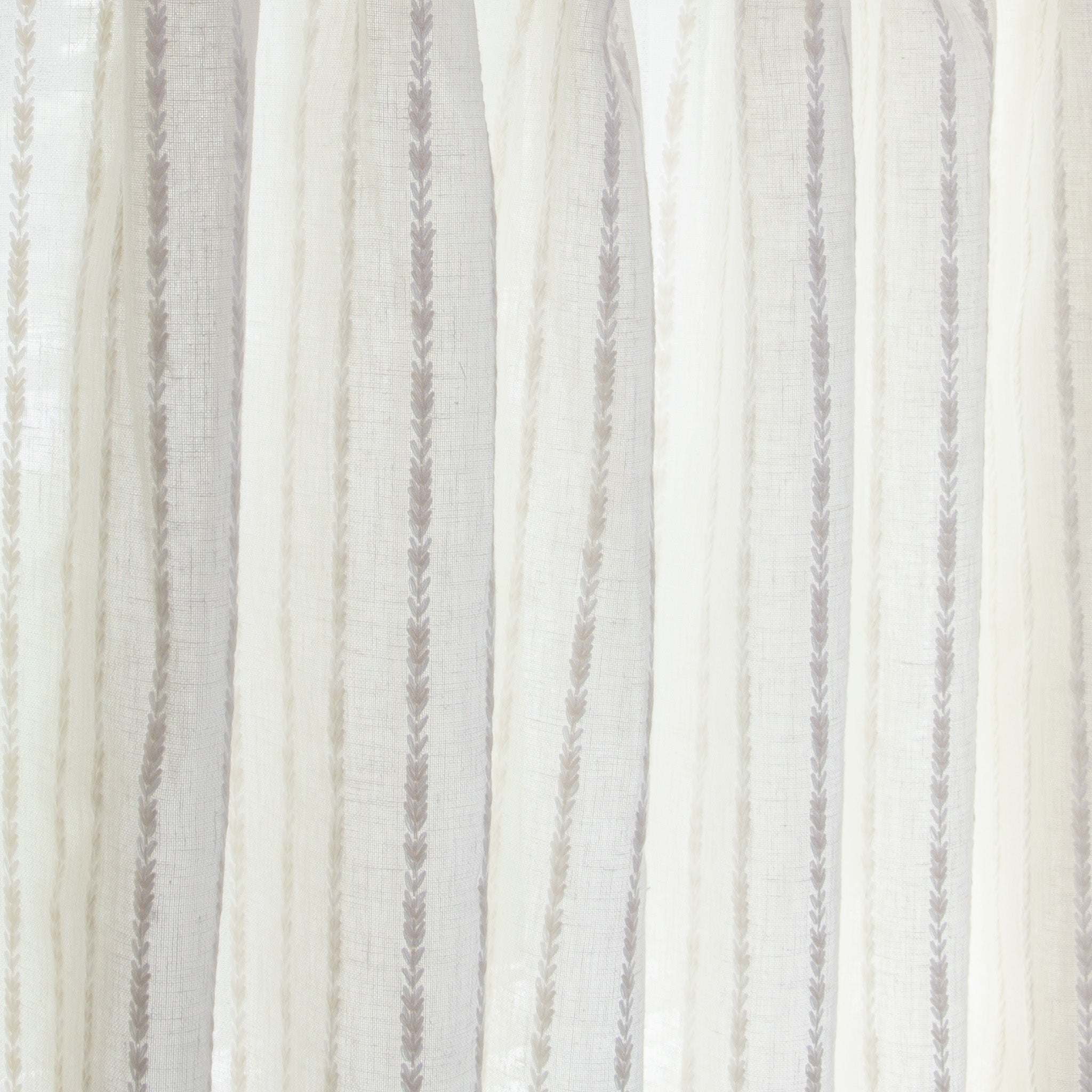 close up of natural white curtain with neutral stripe pattern