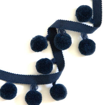 navy blue pom pom curtain and pillow trim