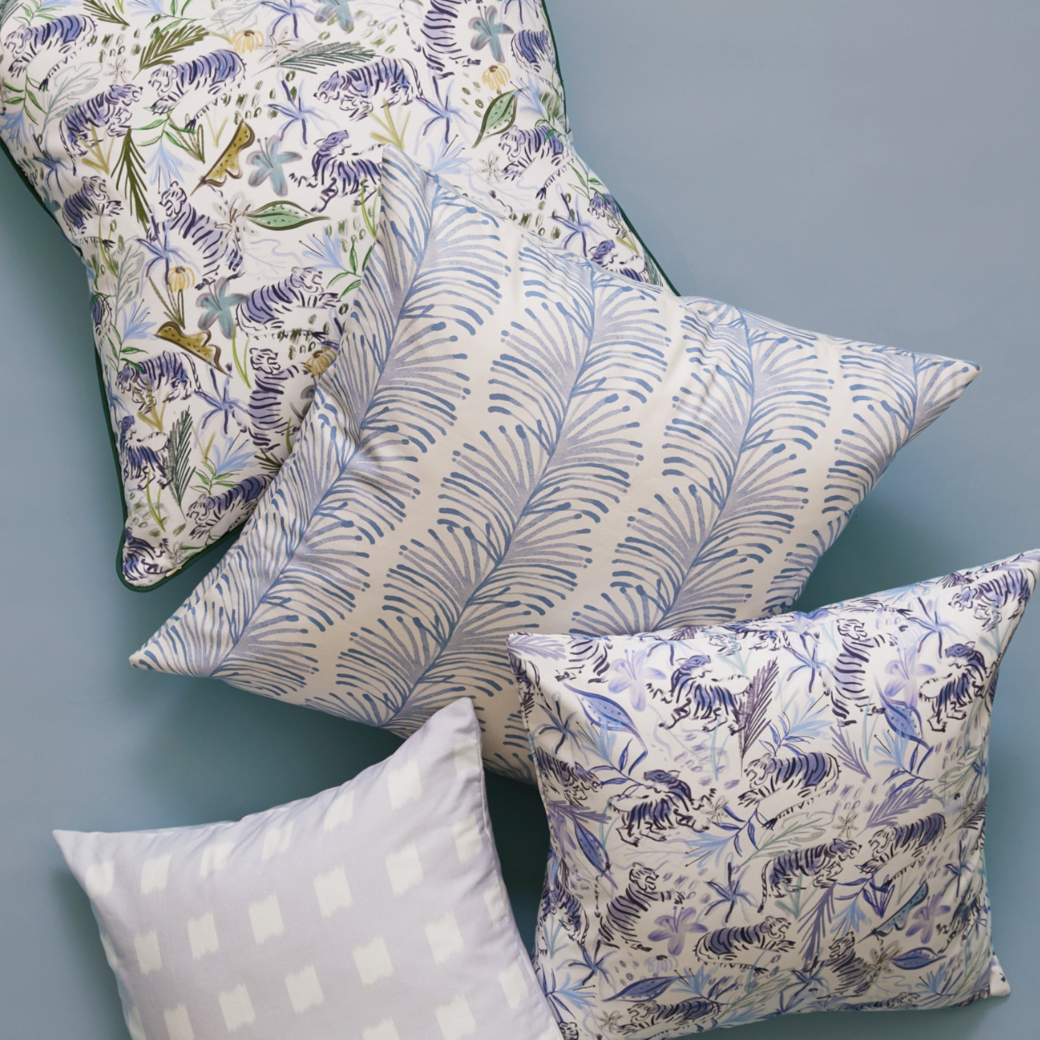 Close-up of Green Tiger Printed Pillow, Blue With Intricate Tiger Design Printed Pillow, Sky Blue Botanical Stripe Printed Pillow, and Sky Blue Pattern Printed Pillow