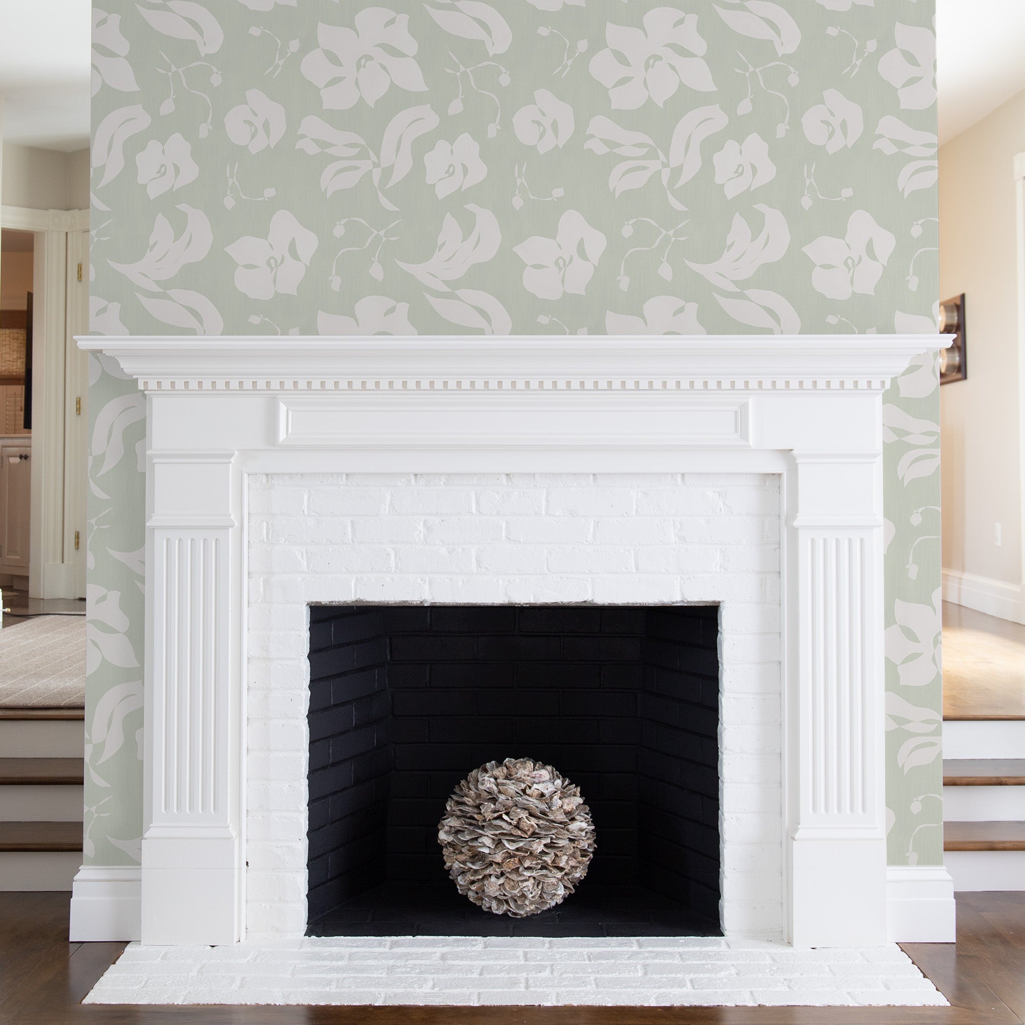 green and white floral wallpaper on a wall with a white mantle