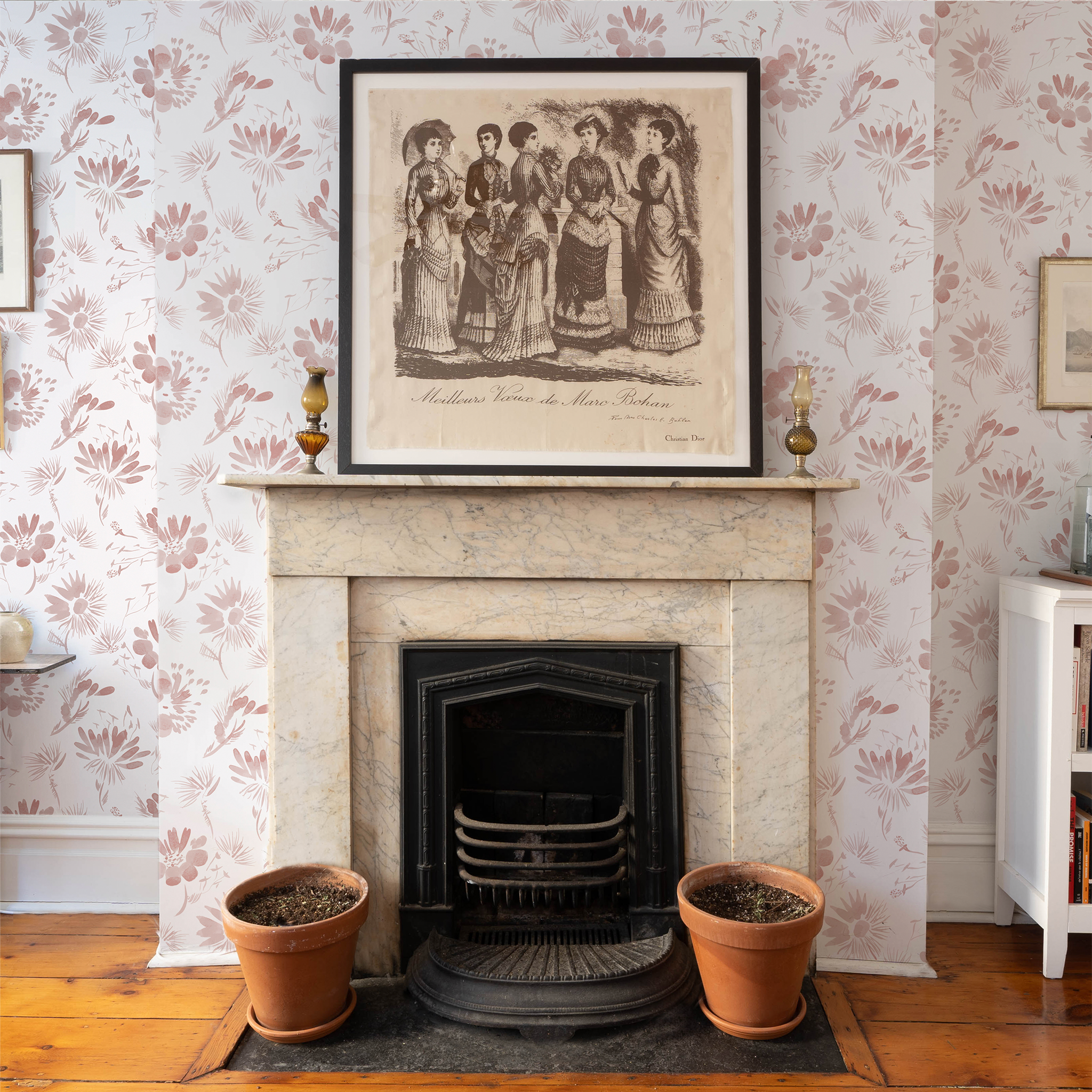 Fireplace styled with framed artwork hung on Pink Floral Custom Wallpaper