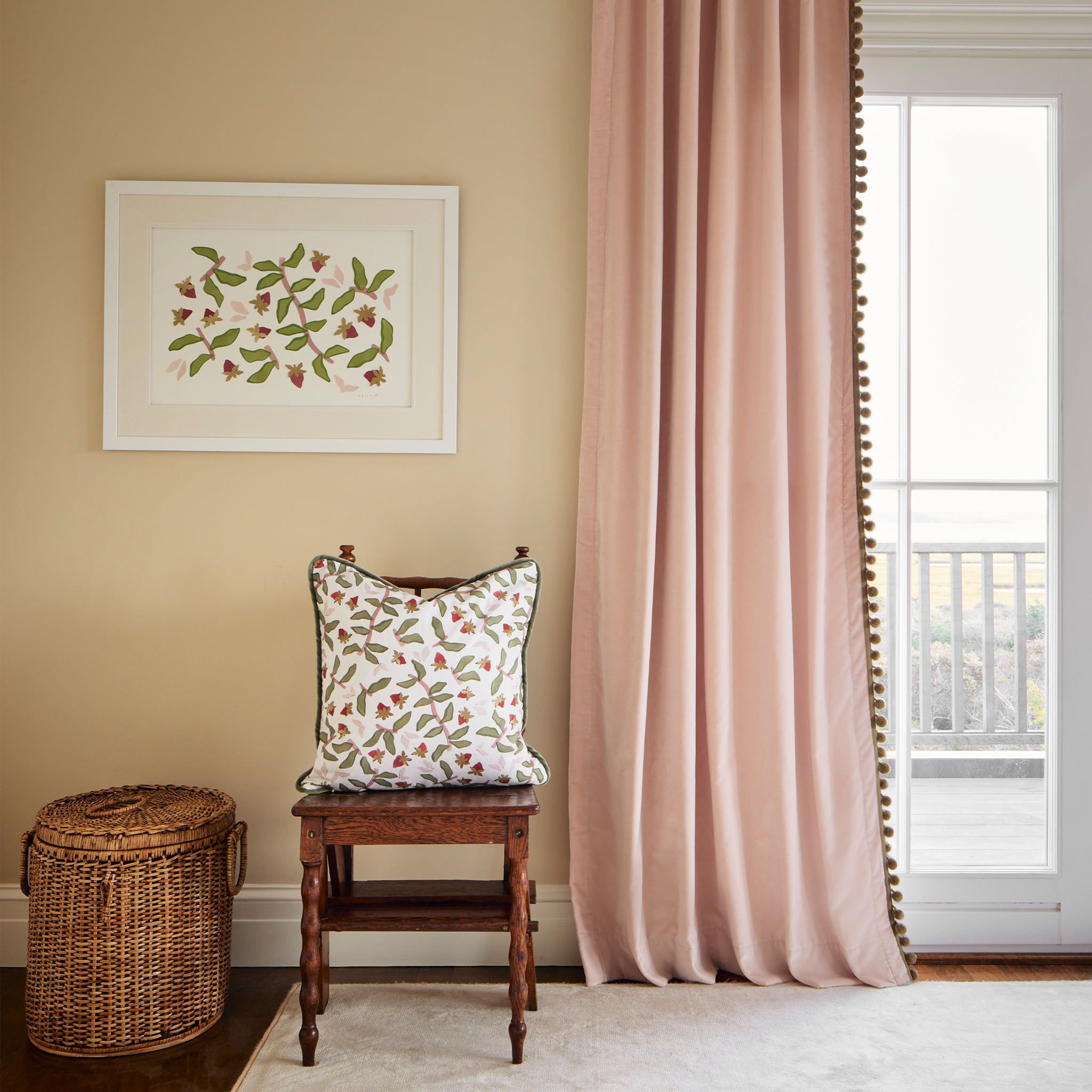 Corner styled with Pink Velvet with sage green pom pom next to wooden chair with Strawberry & Botanical Printed Pillow and Strawberry & Botanical Artwork hung on wall