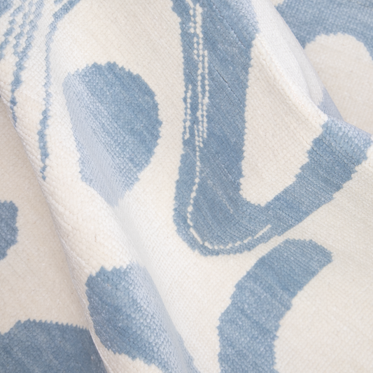 Close up of abstract sky blue and white dhurrie rug 