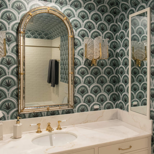 Green and black art deco palm pattern wallper in bathroom with gold mirror and fixtures
