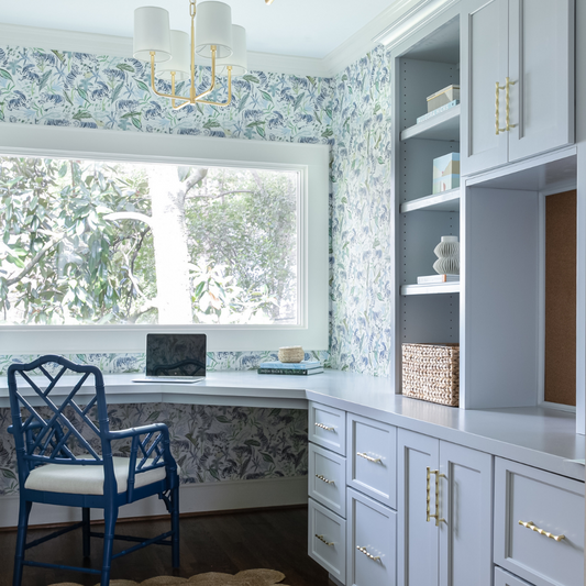 Office with green tiger chinoiserie wallpaper and light blue painted cabinets and shelves with a large picture window looking outside
