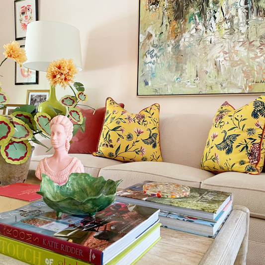Coral Velvet and Yellow Chinoiserie custom pillows styled on white couch in a living room next to a green lamp and a coffee table in the front