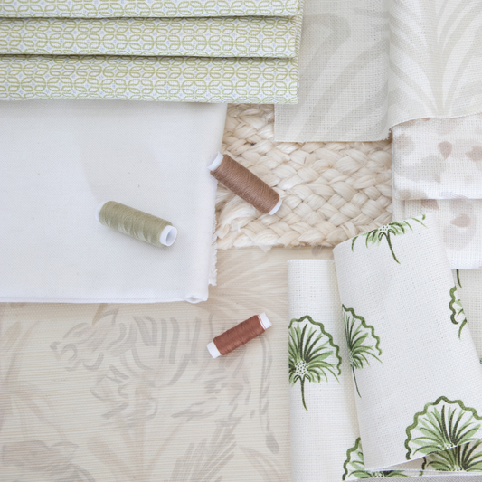 Natural interior design moodboard with beige tiger grasscloth wallpaper and green floral fabric and blue and green geometric fabric