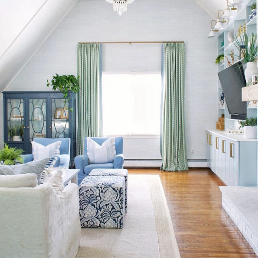 Living room styled with Coastal Inspired Green and Blue custom curtains on illuminated window next to wooden blue cabinet