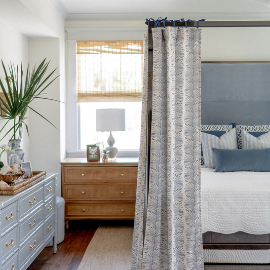 Canopy bed styled with Sky Blue Botanical Stripe Custom Curtains hanging on top next to baby blue dresser and wooden nightstand with white lamp on top 
