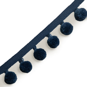 navy blue pom pom curtain and pillow trim