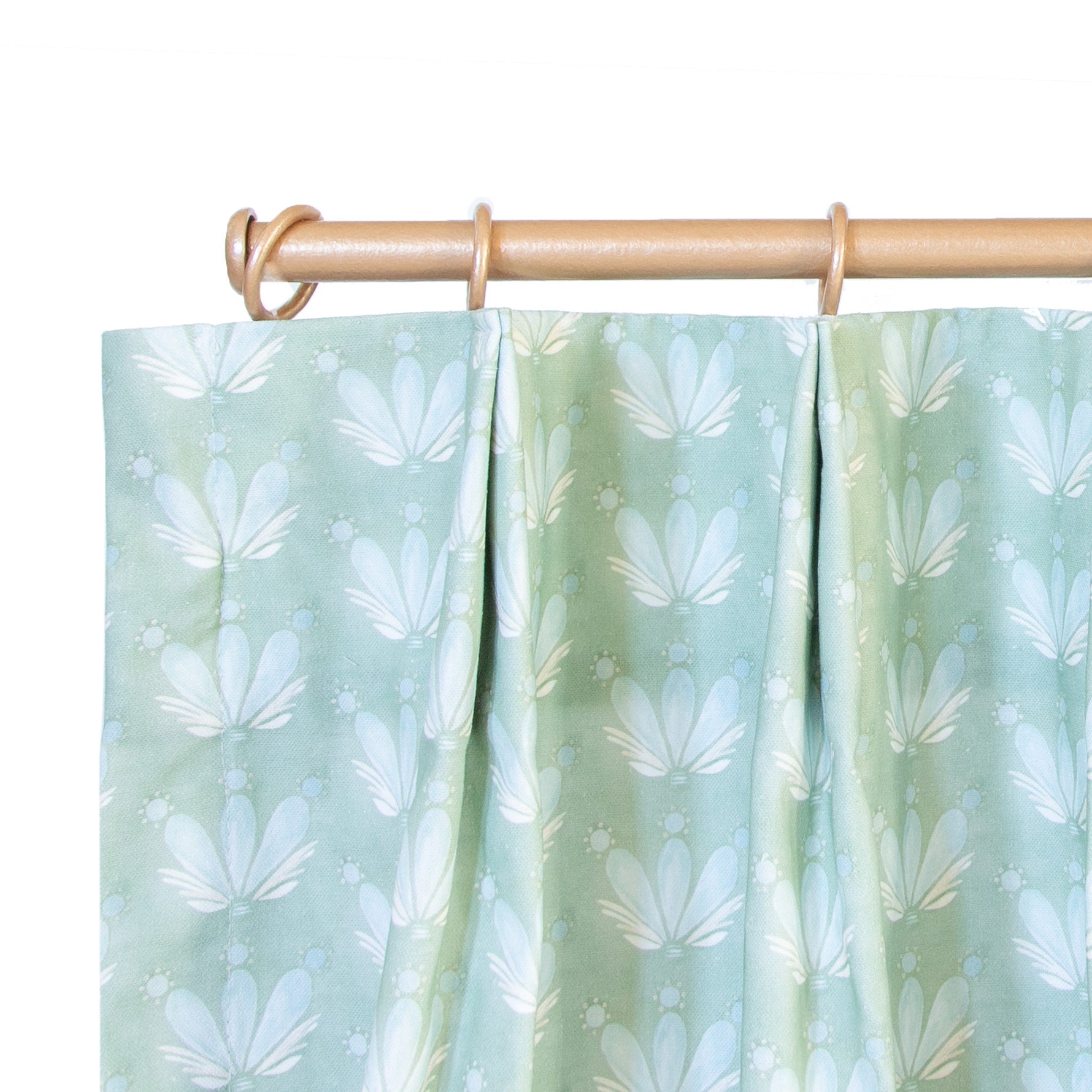 close up of tailored pleat Blue & Green Floral Drop Repeat cafe curtain on a light brown rod
