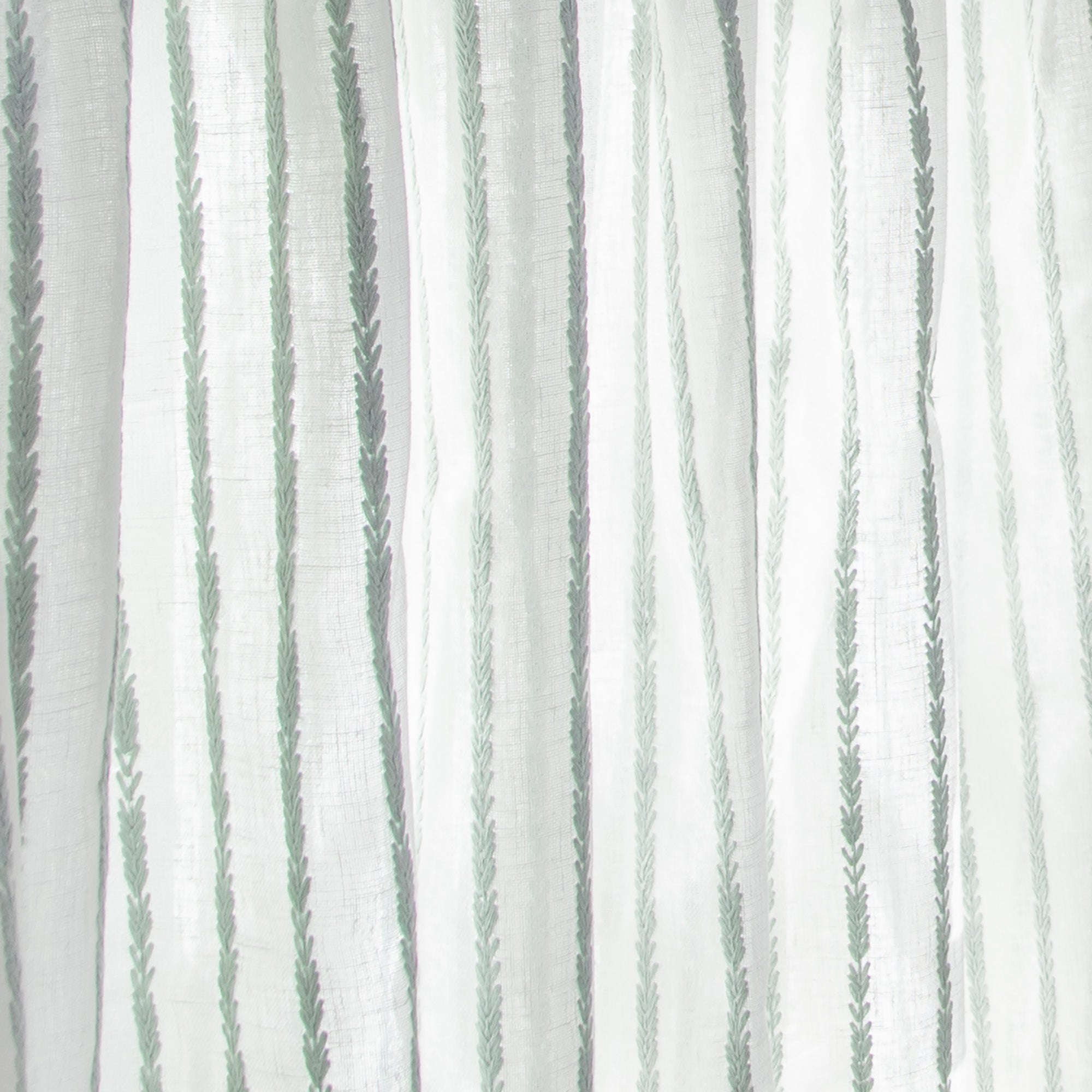 close up of sheer white curtain with embroidered mint green stripe pattern