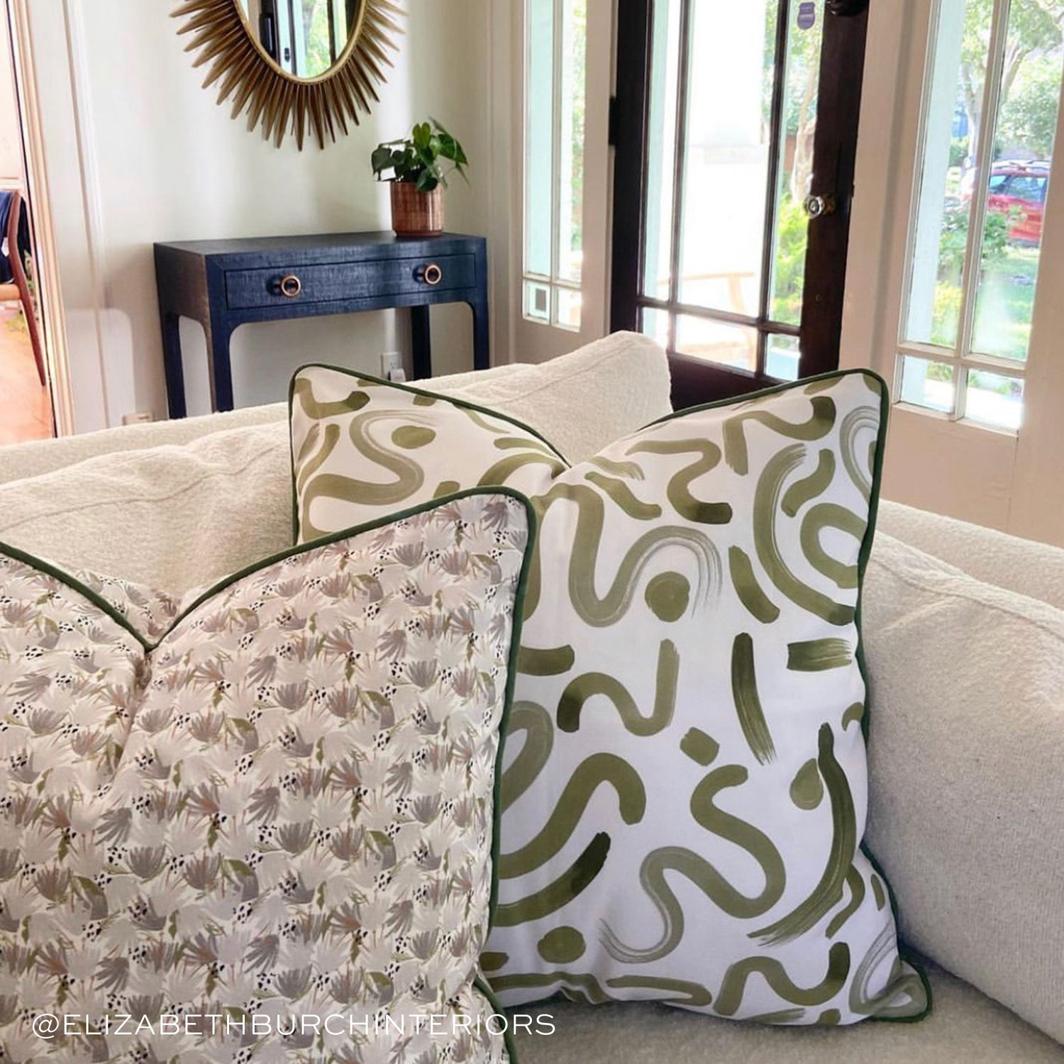 Living room styled with Grey Floral Printed Pillow and Moss Green Printed Pillow on cream couch near wooden front door. Photo taken by Elizabeth Burch