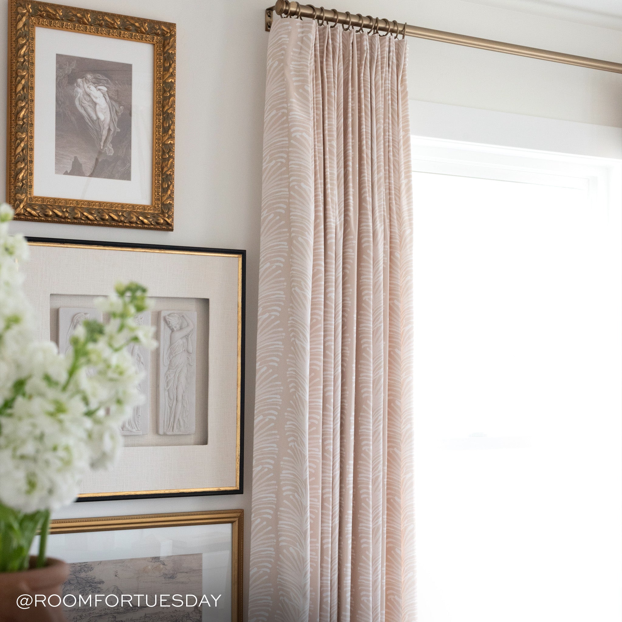 beige botanical stripe pattern curtains hung on a metal rod in front of an illuminated window