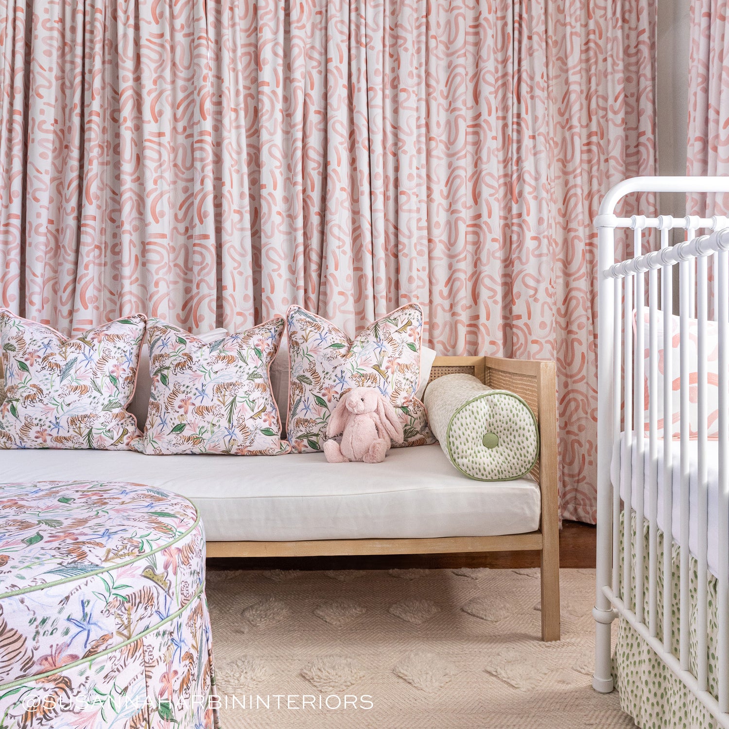 Nursery room corner styled with Pink Chinoiserie Tiger Printed Pillows on wooden bench with white mattress matching with a Pink Chinoiserie Tiger Printed Ottoman with Pink Graphic Printed Curtains. Photo taken by Susanna Harbin Interiors