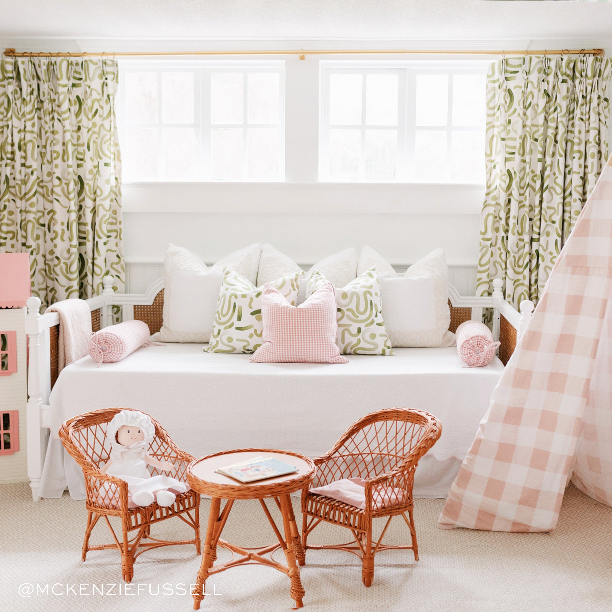 Kid's bedroom styled with Moss Green Printed Pillows on white bed by kid's brown table with two chairs and Moss Green Printed Curtains in the back by illuminated window. Photo by Mckenzie Fussell