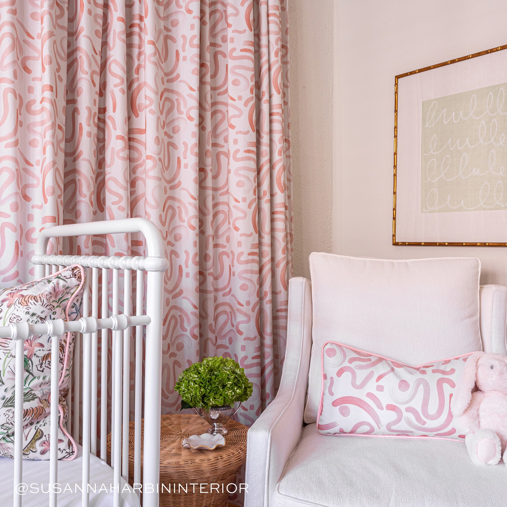 Nursery room corner styled with Pink Graphic Printed Lumbar on Pink Sofa Chair next to white crib with Pink Chinoiserie Printed Pillow. Photo taken by Susanna Harbin Interiors