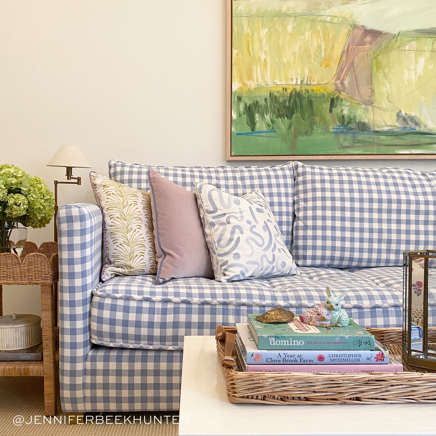 Living room styled with Yellow Stripe Chartreuse Printed pillow, pink velvet pillow, and sky blue printed pillow on blue and white couch next to white coffee table with books and decorations. Photo taken by Jennifer Hunter
