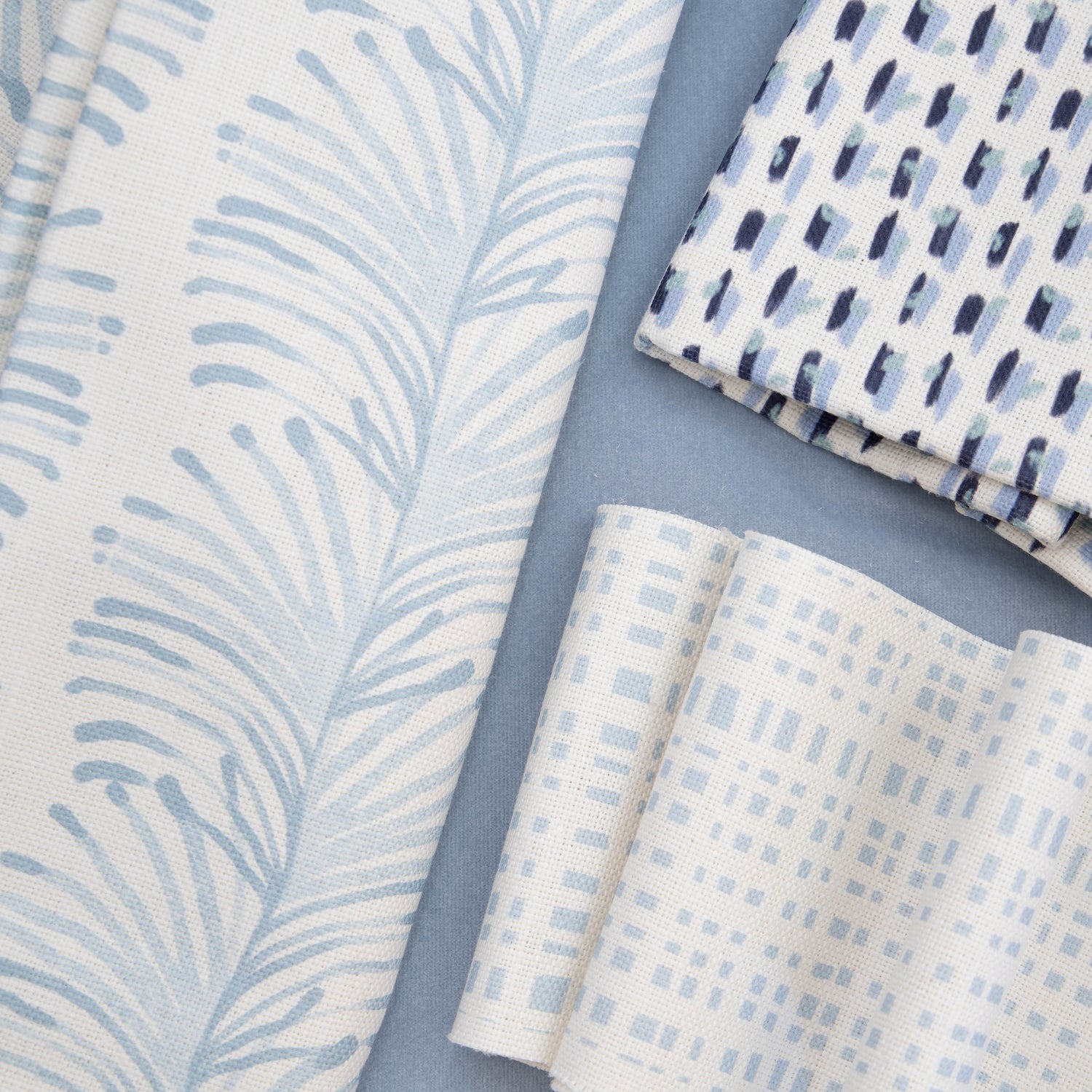 Close-up of Interior design moodboard and fabric inspirations with Sky Blue Gingham Printed Swatch, Sky Blue Botanical Stripe Printed Swatch, and Sky and Navy Blue Poppy Printed Swatch