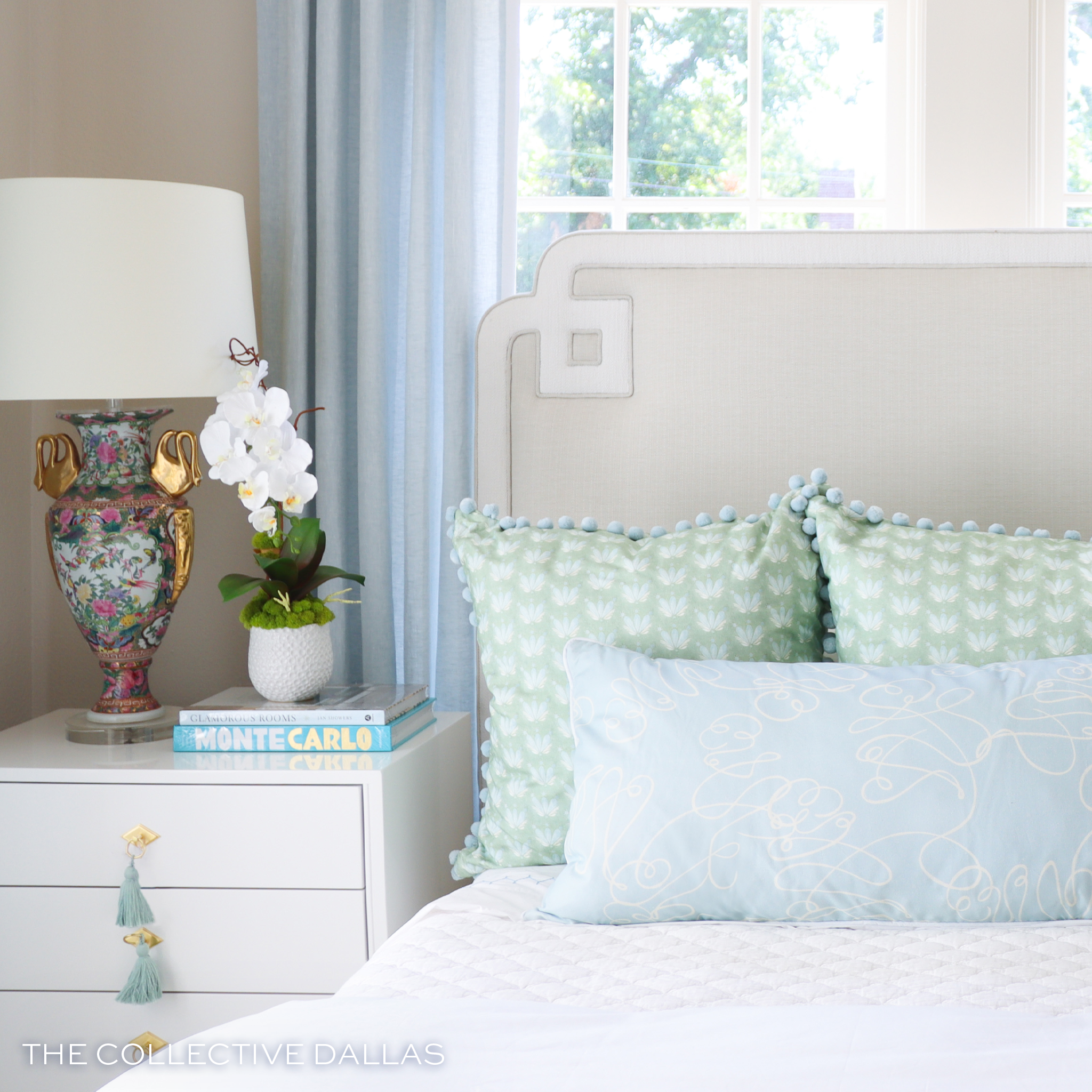 Close-up of white bed styled with one Powder Blue Abstract Printed Pillow and two Coastal Inspired Green Printed Pillows