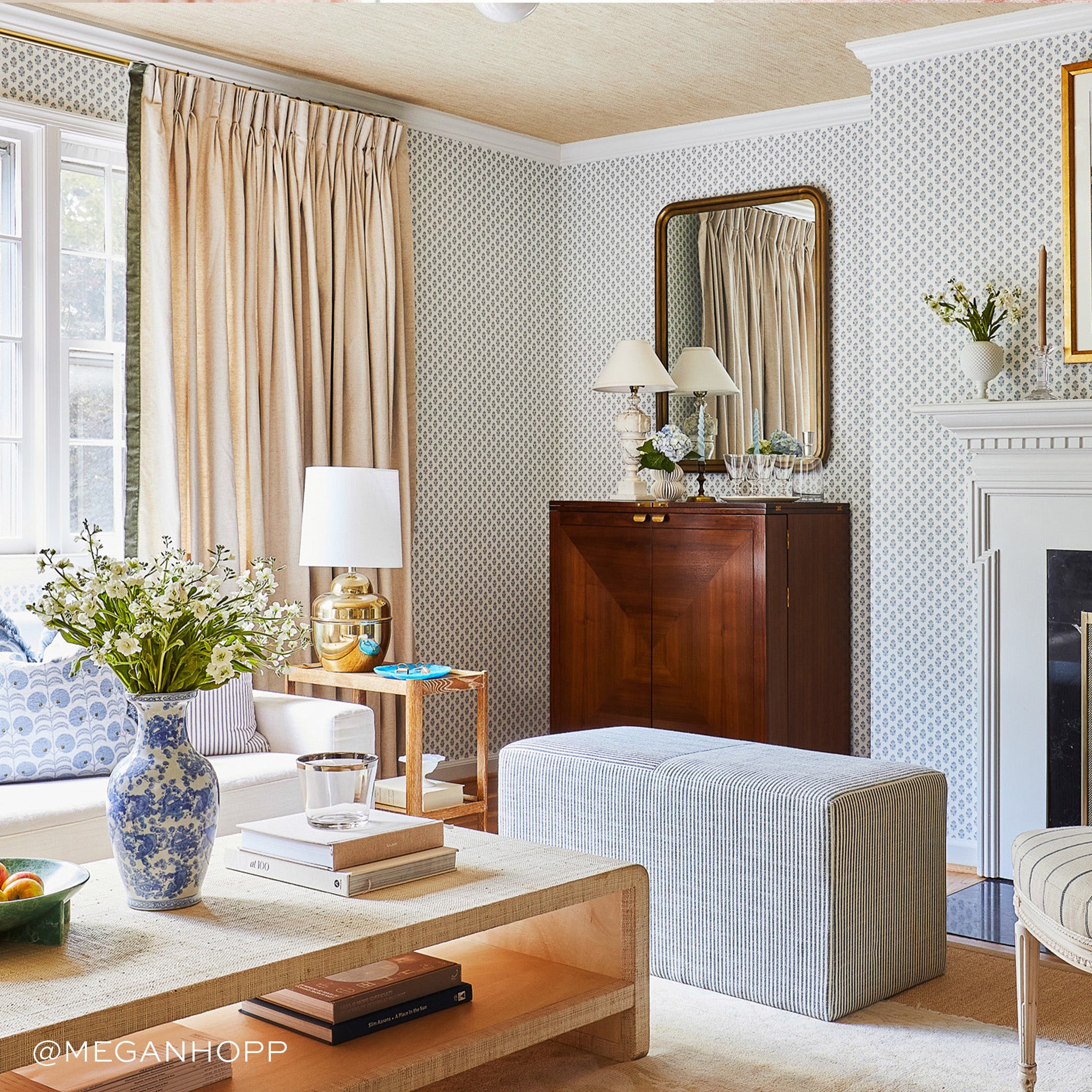 Living room styled with Linen Oat Curtains with Fern Green Velvet Band next to white couch with blue and white pillows by wooden coffee table with white flowers on blue and white vase next to stacked books. Photo taken by Megan Hopp