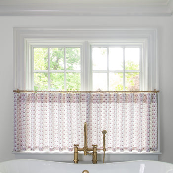 Pink & Burgundy Drop Repeat Floral Printed Cotton curtain on a metal rod in front of an illuminated window in a bathroom 