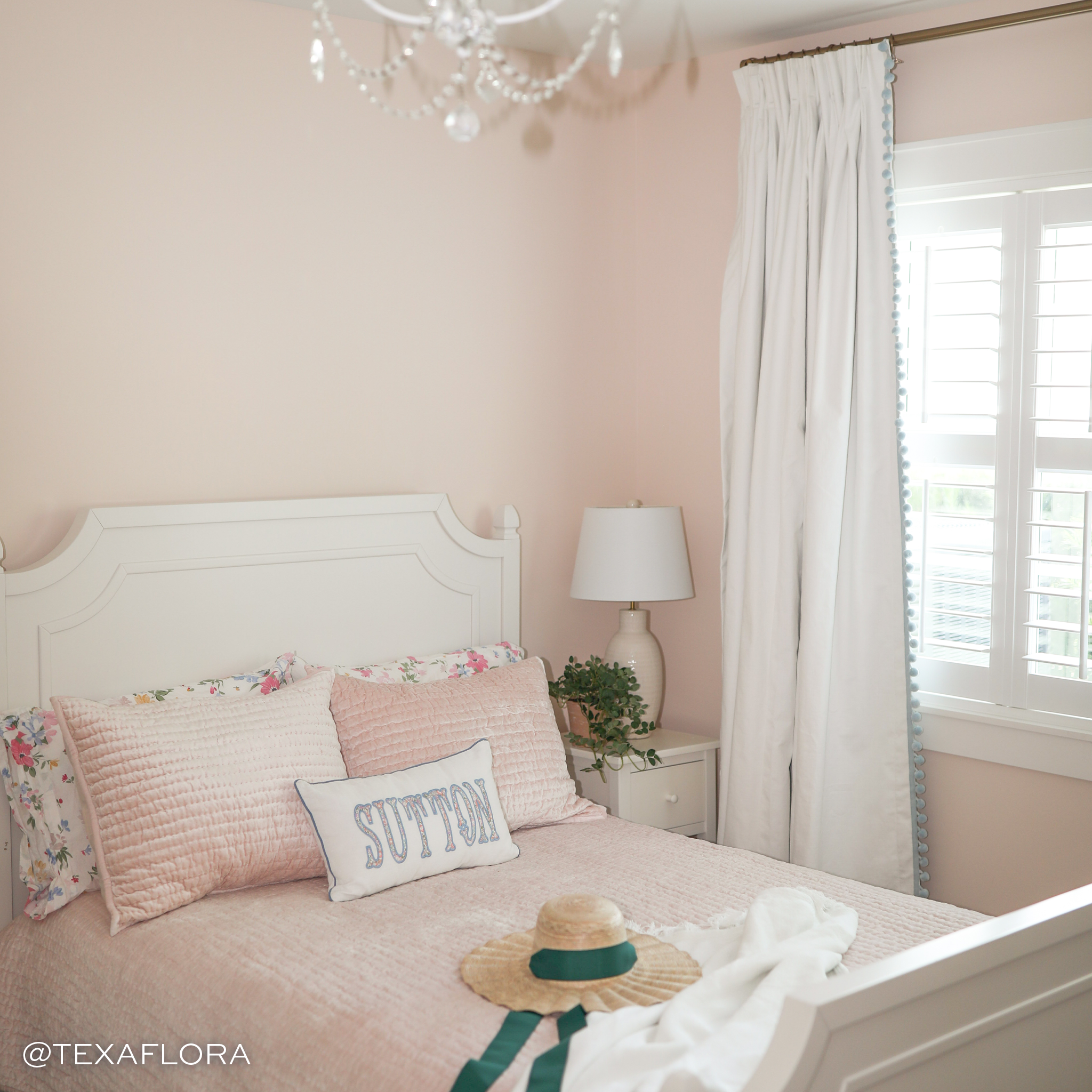 White Cotton Curtains in a pink room behind a bed with pink bedding and straw hat 