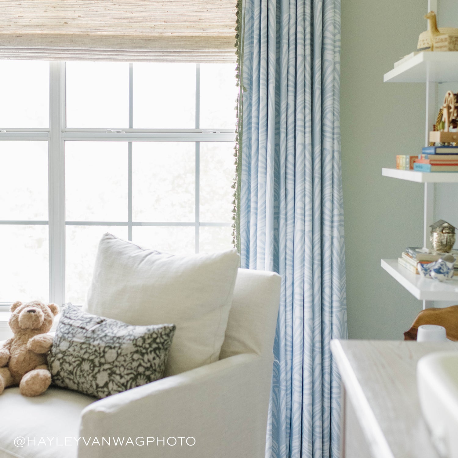 Window close-up with white sofa chair and sky blue palm printed curtains. Photo taken by Hayley Van Wageningen