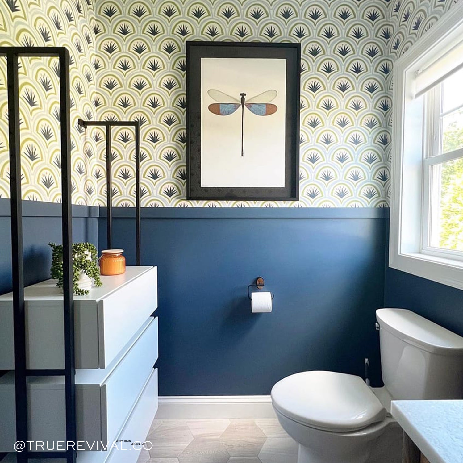 Bathroom styled with Art Deco Palm Pattern Printed Wallpaper in front of white toilet under window in front of white drawers. Photo taken by True Revival Co