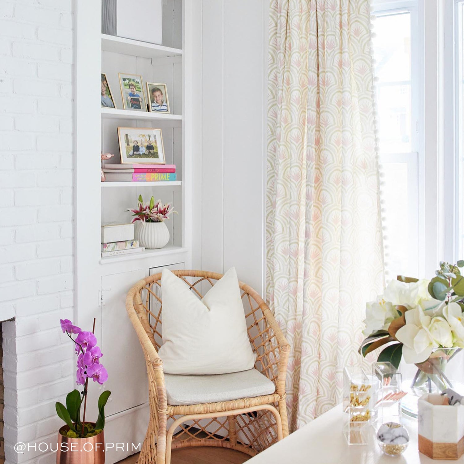 Room corner with white pillow on wooden chair styled with Pink Art Deco Palm Printed Curtains on illuminated window. Photo taken by House of Prim