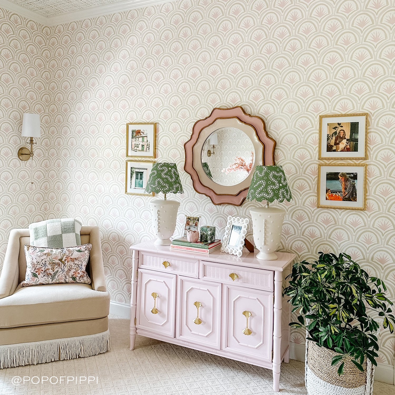Room corner styled with a Pink Art Deco Palm Printed Wallpaper with a mirror hung on wall on top of pink dresser next to beige sofa chair. Photo taken by Pop of Pippi