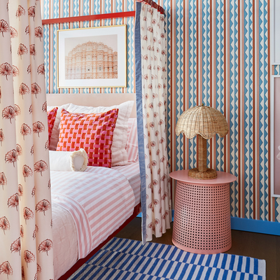 abstract stripe pattern wallpaper, Rose Floral curtains with sky blue velvet band surrounding a bed with pink pillows on it and a blue striped rug