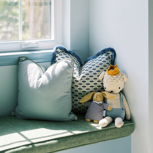 Willow Amalfi pillows in soft blue and patterned fabric with plush toys on a sunlit bench, made-to-order in the USA
