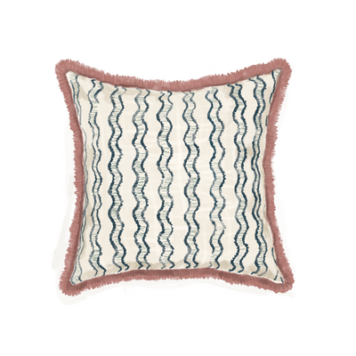 close up of hand drawn pillow with blue wavy stripes and pink fringe on the pillow 