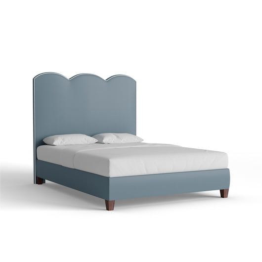 The Harbor bed by Pepper Home features a custom scalloped headboard in linen fabric, adding charm and sophistication.