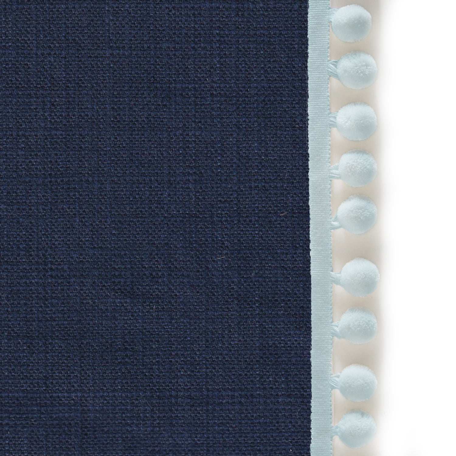Upclose picture of Midnight custom Navy Bluecurtain with powder pom pom trim