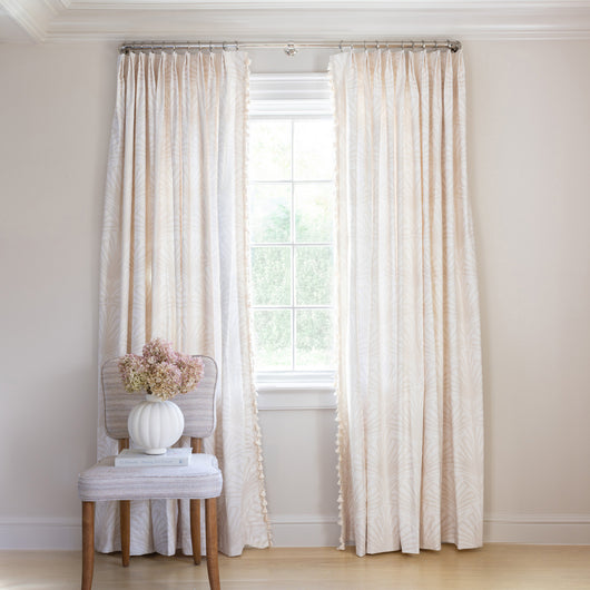 Suzy Sand Tailored Pleat custom curtains by Pepper Home with hand-painted palm and scallop pattern in soft beige tones.