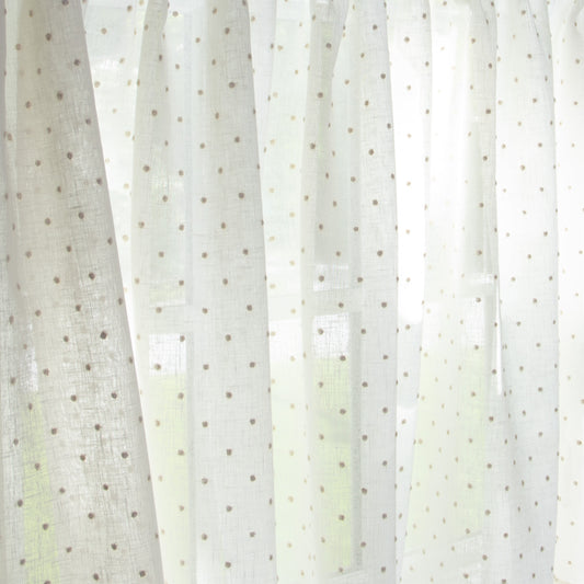 close up of white sheer curtain with neutral embroidered polka dots