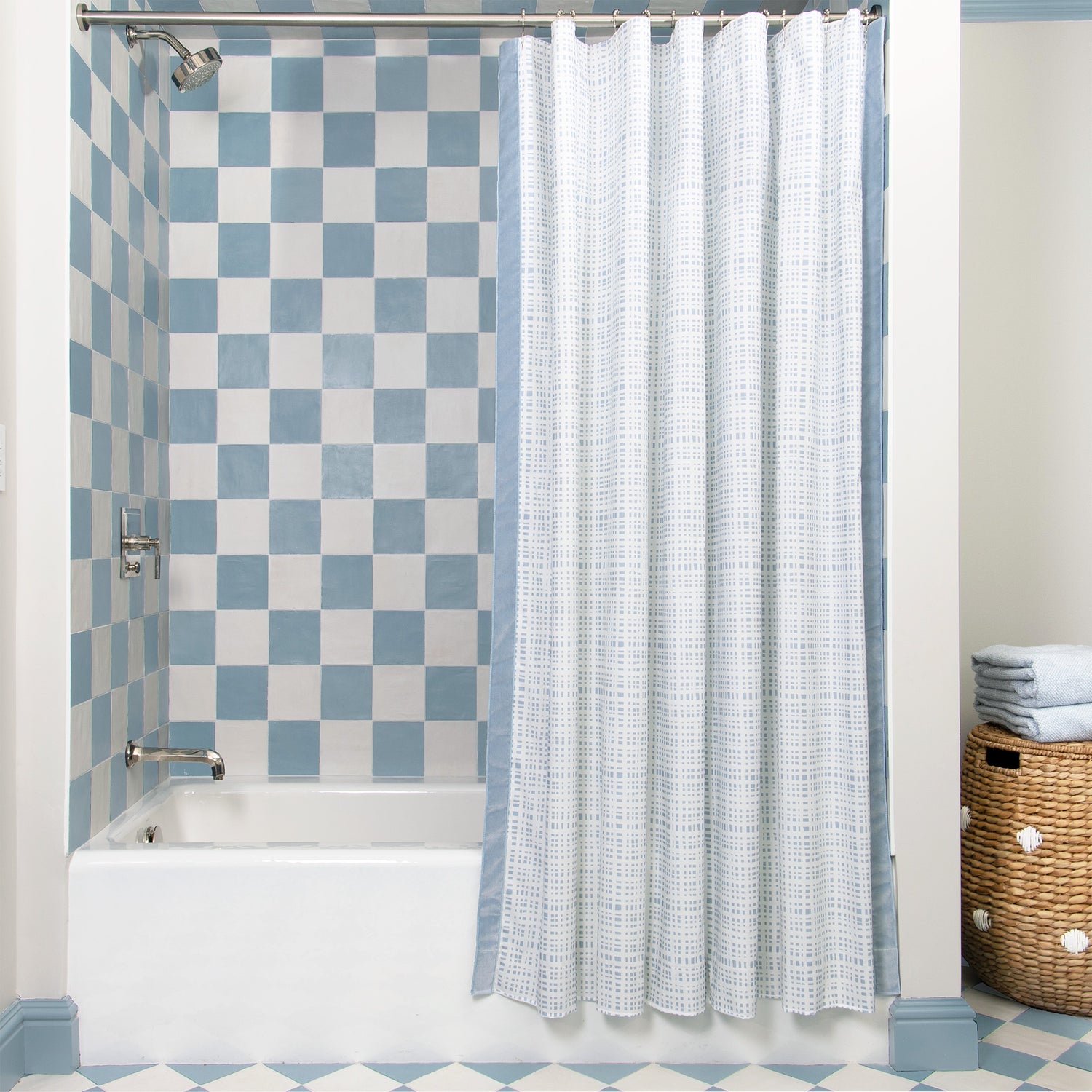 Sky Blue Gingham shower curtain with sky blue velvet band hanging on rod in front of white tub in bathroom with blue and white tiles
