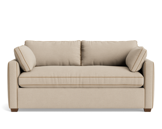 Front view of a light beige upholstered sofa with two back cushions, bolster pillows, and tapered wooden feet