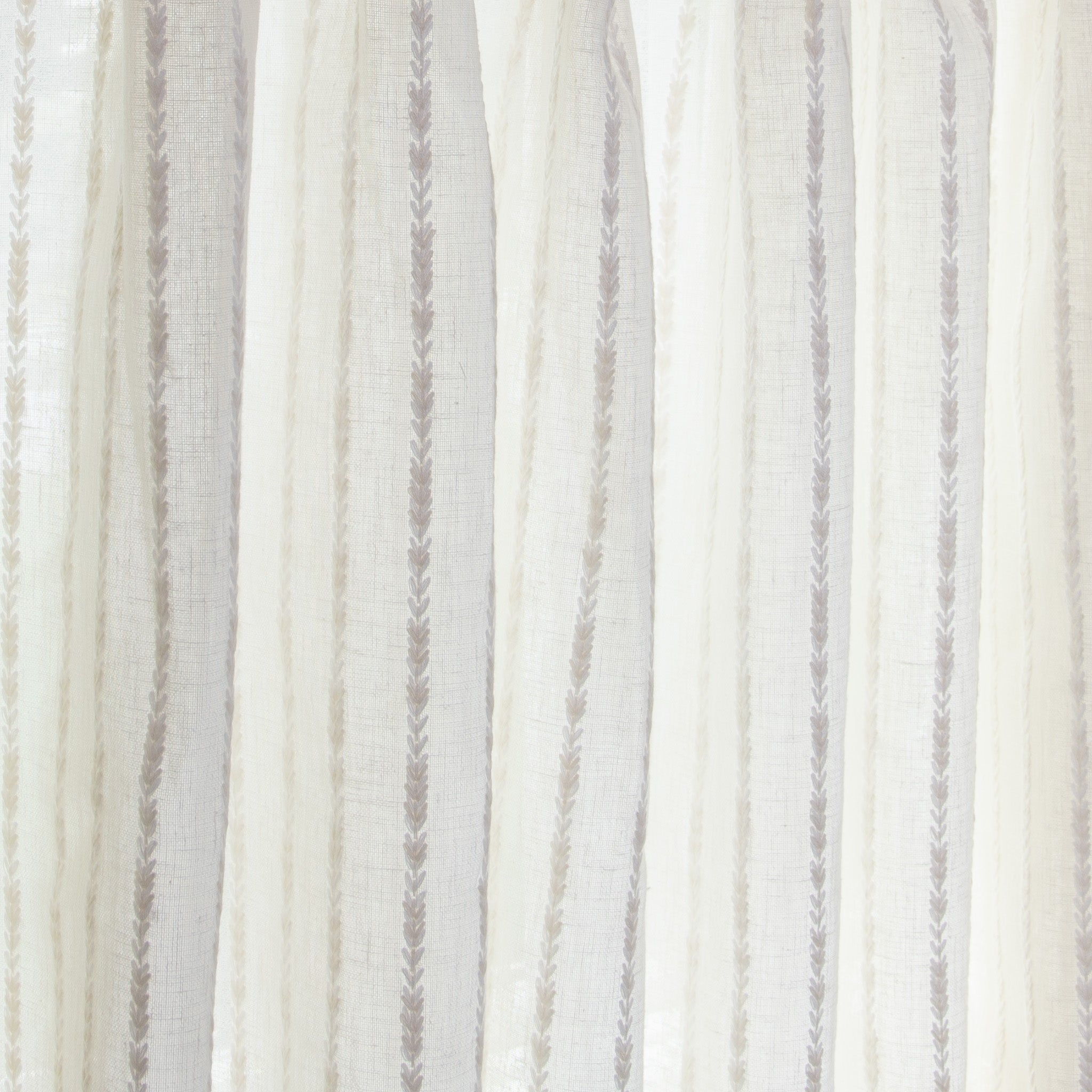 close up of natural white curtain with neutral stripe pattern